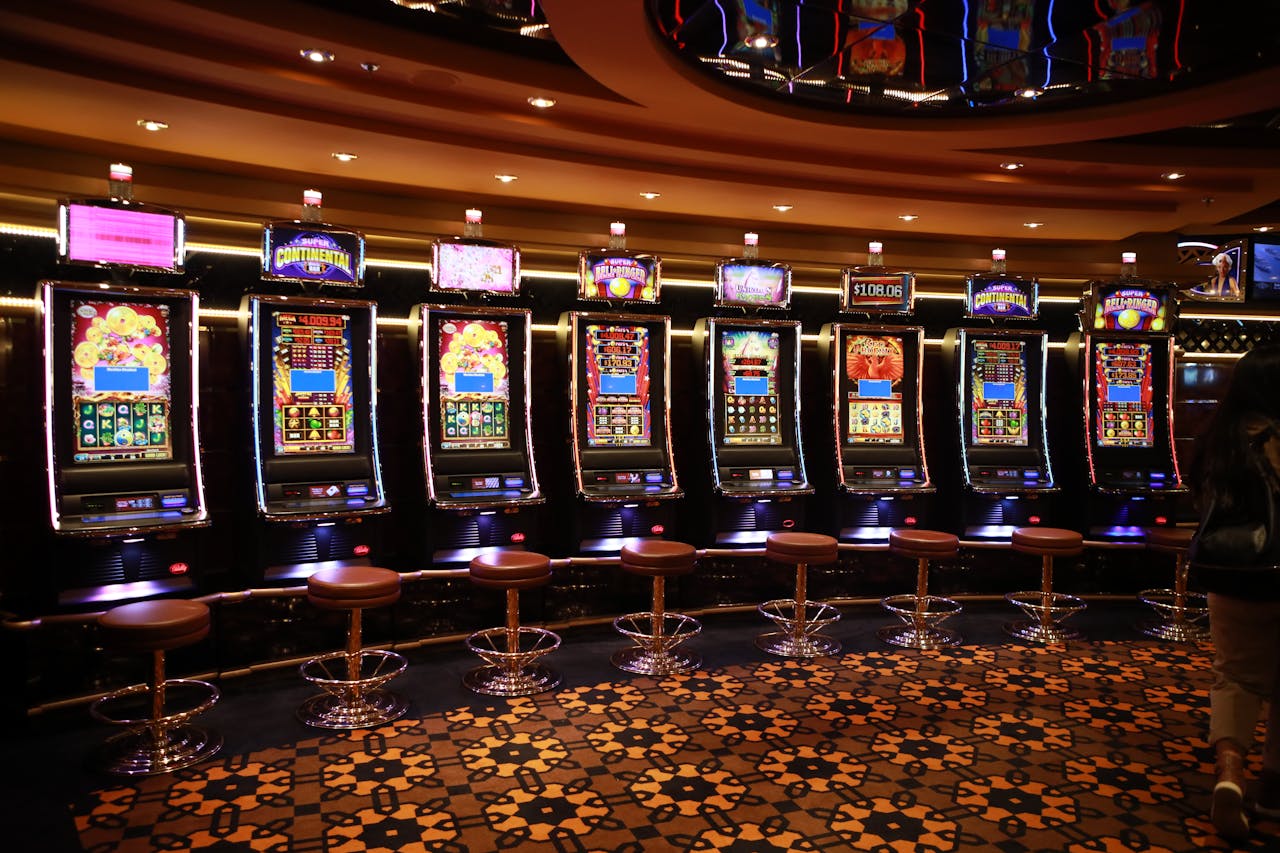 why-choose-us A row of luxury slot machines in a casino interior with plush stools, perfect for gaming enthusiasts.